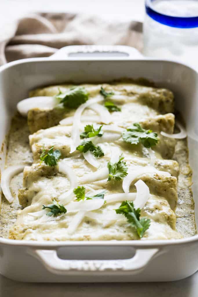 The ingredients for enchiladas suizas include corn tortillas filled with chicken, a creamy green sauce, and loads of cheese!

